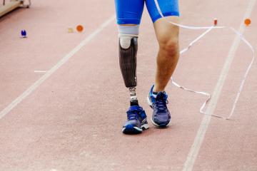 Athlete with prosthetic leg crossing finish line