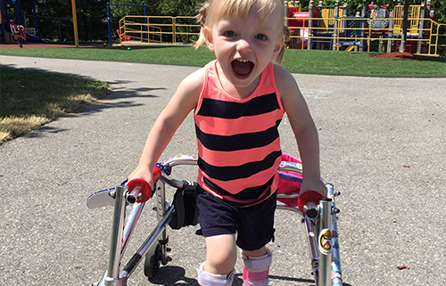 happy child with walking disability using a walker